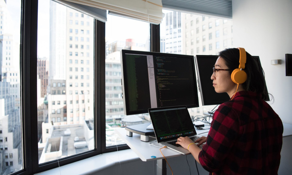 woman sitting while operating macbook pro