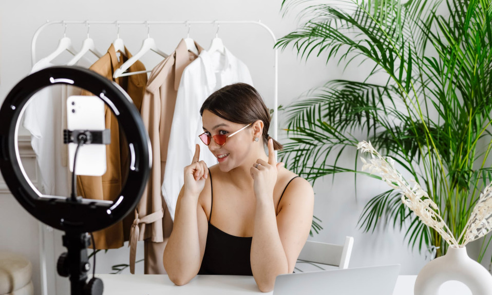 a woman showing her sunglasses to a video recording