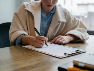 focused woman writing in clipboard while hiring candidate